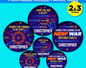May include: Printable circle favor tags for a Nerf War birthday party. The tags are 2 and 3 inches in diameter and feature a blue background with neon orange and yellow accents. The text on the tags includes "Thanks for coming to my party", "I hope you had a blast!" and "Nerf War Birthday Party!"