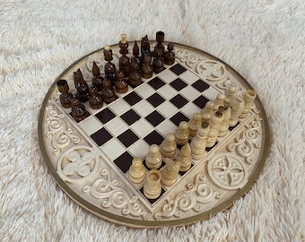 May include: A wooden chess set with a round board featuring intricate carvings. The board has a brown and white checkered pattern. The chess pieces are made of wood and are in the middle of a game.