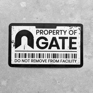 May include: A black and white rectangular sticker with the text "PROPERTY OF GATE" and "DO NOT REMOVE FROM FACILITY". The sticker has a barcode and a stylized gate logo.