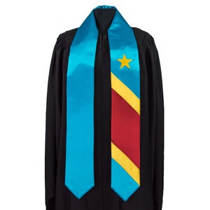 May include: A graduation stole with a blue and yellow diagonal stripe and a red stripe. The stole features a yellow star in the upper left corner.