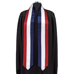 以下が含まれることがあります： 赤、白、青のストライプの卒業式用サッシュ。サッシュはサテン製で、首に結ばれています。