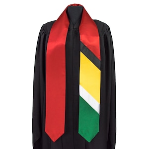 May include: A graduation stole with a red and green sash featuring the colors of the flag of Guyana. The stole is worn over a black graduation gown.