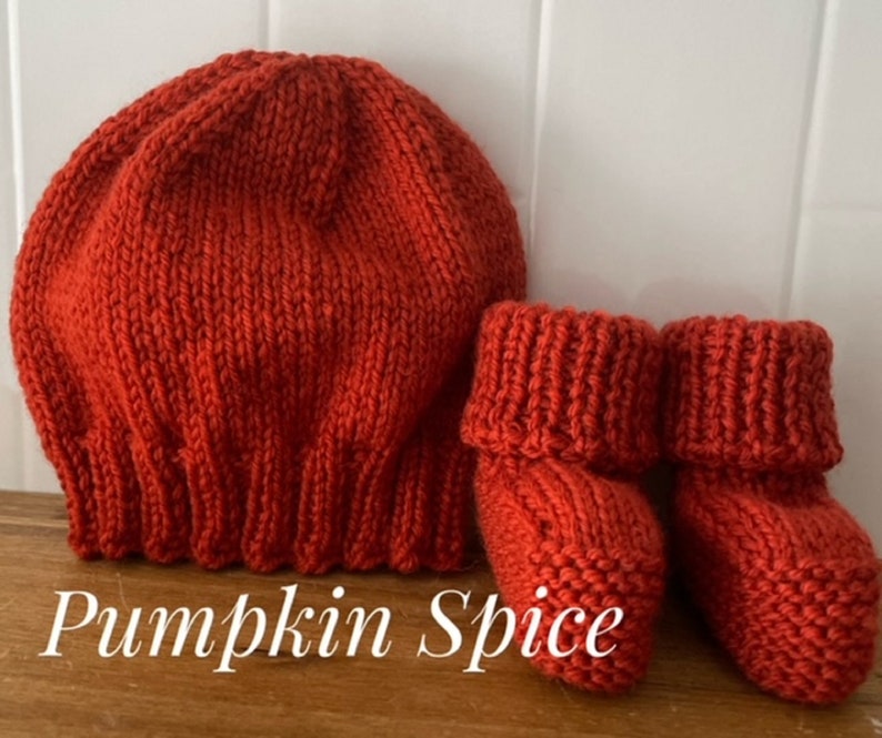 May include: A knitted pumpkin spice colored baby hat and matching booties. The hat is a round, ribbed design. The booties have a folded cuff. The text "Pumpkin Spice" is at the bottom of the image.