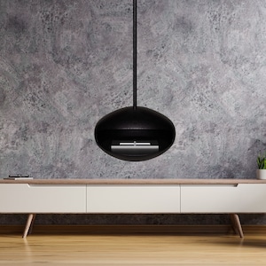 Peut inclure: Un salon moderne avec une cheminée suspendue noire, un meuble TV blanc, un fauteuil bleu et une petite table d'appoint en bois avec un vase de fleurs. La pièce a un mur en béton et un sol en bois.