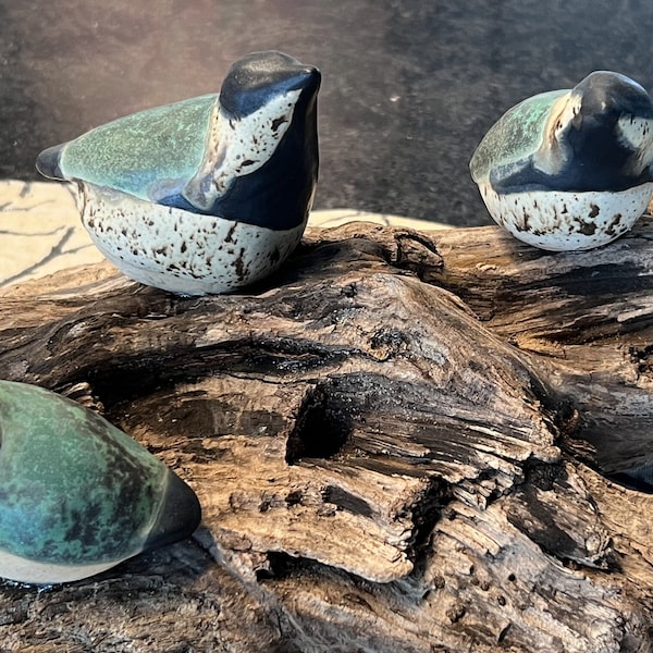 Ceramic birds perched on driftwood.