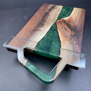 May include: A large wooden cutting board with a green epoxy resin inlay. The board has a built-in handle and the text "OT-028" is visible on the side.