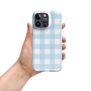 Puede incluir: Una funda de teléfono azul claro con un patrón de cuadros blancos y azules.