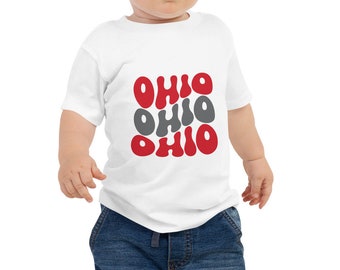 May include: A white baby onesie with a red and gray graphic of the word "Ohio" repeated four times.