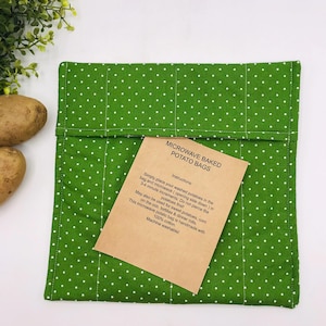Puede incluir: Bolsa de patatas para microondas verde con lunares blancos. Una inserción de papel marrón proporciona instrucciones de uso. La bolsa está hecha de 100% algodón y es lavable a máquina. El texto en la inserción dice "Bolsas de patatas al microondas".