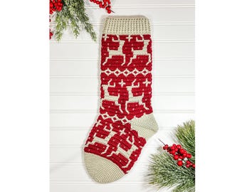 May include: A handmade Christmas stocking in red and cream. The stocking features a reindeer pattern and is made of crocheted yarn. The toe and cuff are cream-coloured, while the body is red with cream-coloured reindeer and geometric designs.