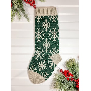 May include: A green and white crocheted Christmas stocking with a snowflake pattern.