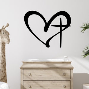 A casual-shaped heart outline and cross are connected together to hang on the wall as a single piece.