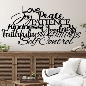 The words love joy peace patience kindness goodness faithfulness gentleness and self control are displayed in two different fonts, printed and cursive, upper and lower case lettering and connected together to hang on the wall as a single piece.