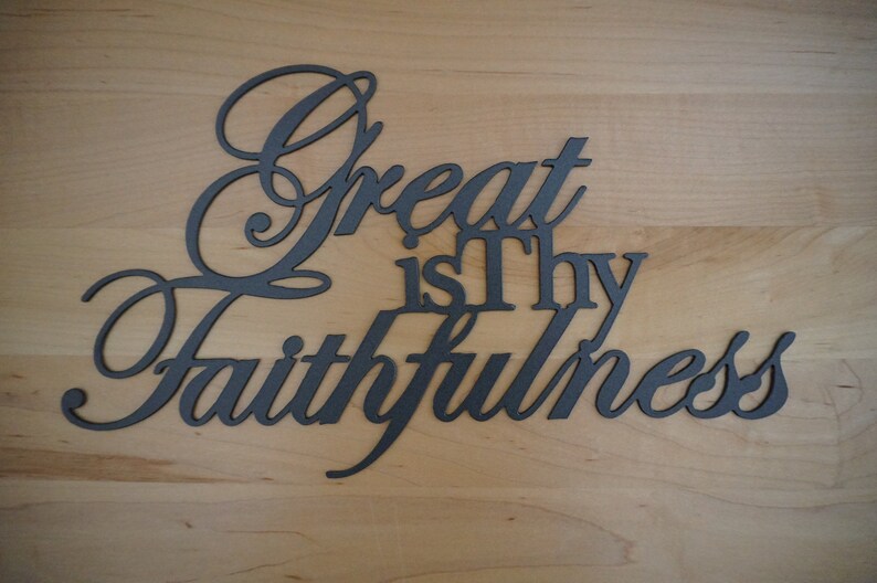 The words Great is Thy Faithfulness are displayed in two different fonts and connected together to hang as a single piece.  Great and Faithfulness are in a highly scripted font with the first letter capitalized.  Other words are in a printed font.