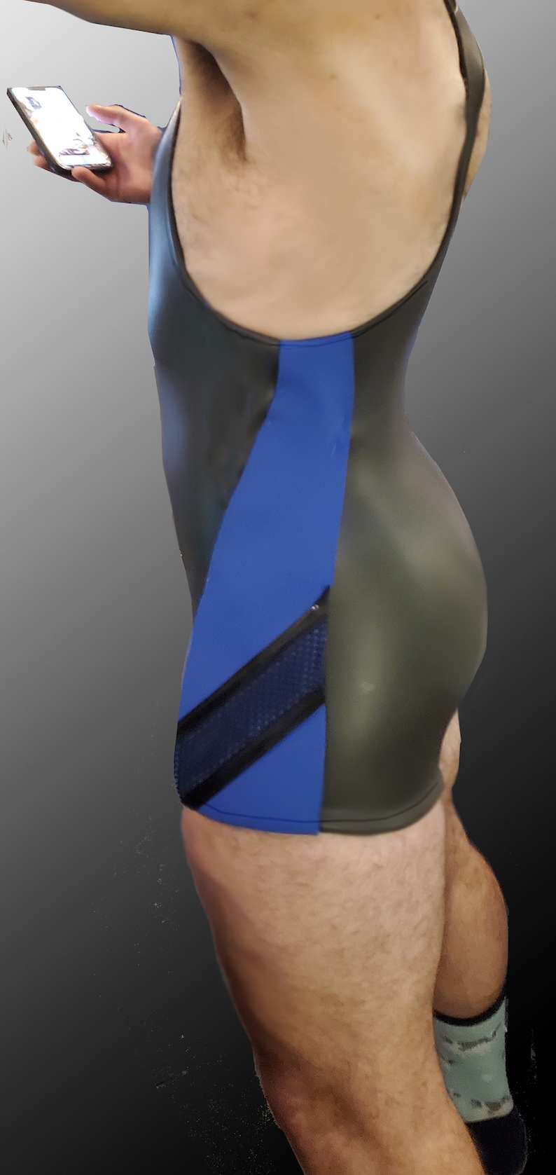 Puede incluir: Un maillot de lucha libre negro y azul con un panel de malla en el lateral.