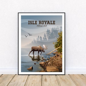 May include: Framed art print featuring a scenic illustration of Isle Royale National Park. A moose wades in a lake, with mountains and trees in the background. The text "Isle Royale National Park" is displayed at the top.