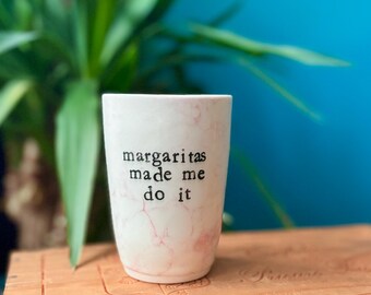 May include: White ceramic mug with a pink marble design and black text that reads "margaritas made me do it".