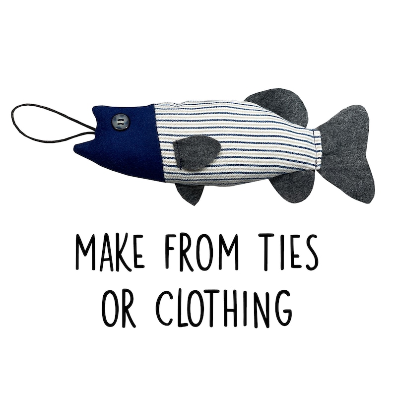 May include: A blue and white striped fabric fish with a blue felt head and a black button for an eye. The fish has a gray felt tail fin and a black cord for a mouth. The text "MAKE FROM TIES OR CLOTHING" is printed below the fish.
