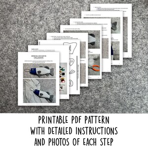 May include: Printable PDF pattern with detailed instructions and photos of each step for making a fish-shaped toy. The pattern includes a striped fabric fish with a blue fin and a white and blue striped fabric fish with a blue fin.