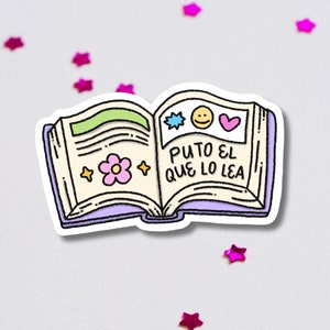 Op de afbeelding: Een sticker van een open boek met een paarse kaft en een witte rand. Het boek heeft een gele pagina met een roze bloem en twee gele sterren, en een roze pagina met een blauwe ster, een gele smiley en een roze hart. De tekst op de roze pagina luidt "Puto el que lo lea".