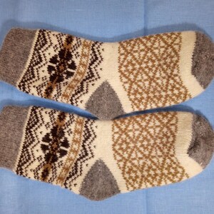 May include: Pair of gray, brown, and white patterned wool socks. The socks have a geometric design.