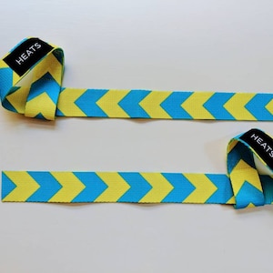 May include: Two lifting straps with a blue and yellow chevron pattern, each with the word "HEATS" printed on them.
