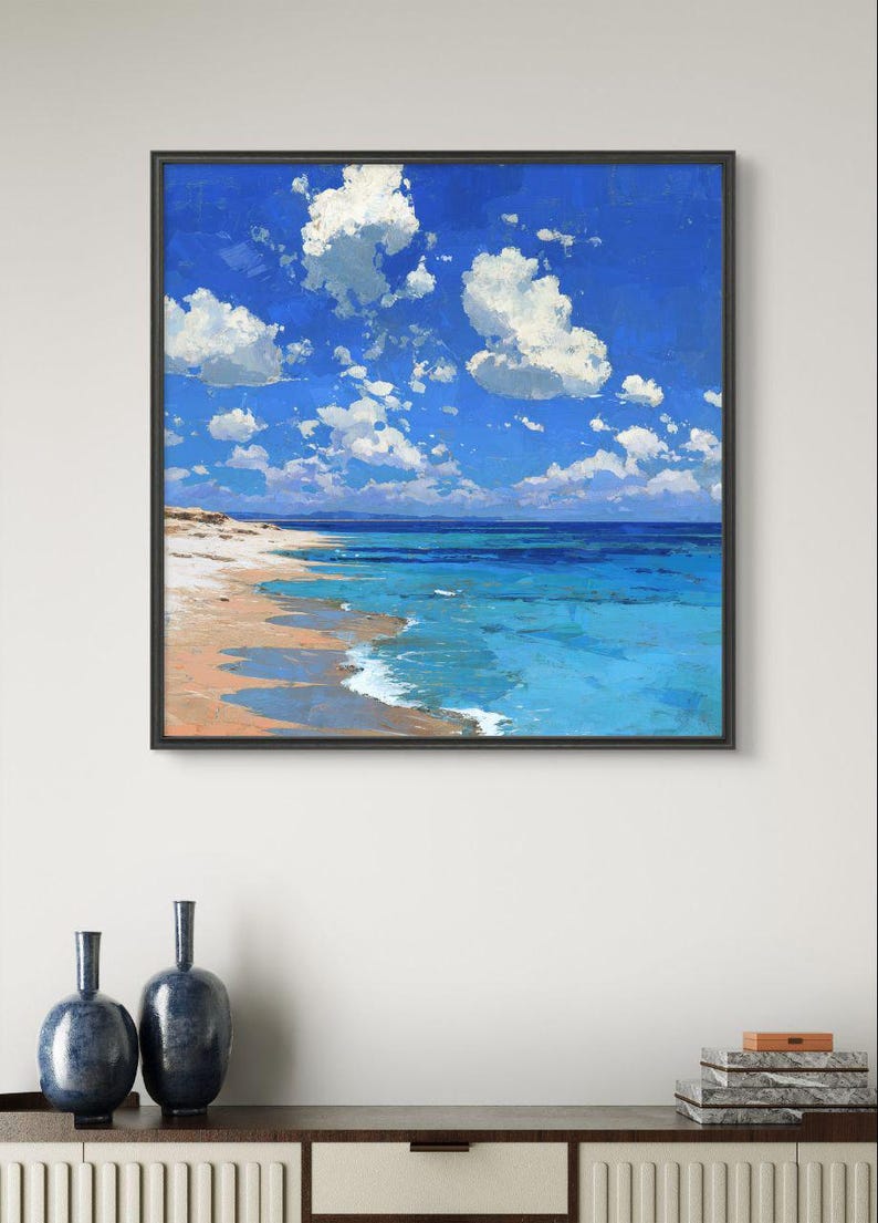 May include: A framed painting depicts a vibrant beach scene. The artwork showcases a bright blue sky dotted with fluffy white clouds. Turquoise water meets a sandy shore, creating a serene coastal landscape. Two dark blue vases sit below the painting.