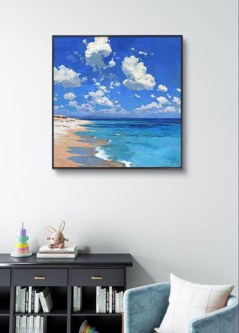 May include: Square framed painting of a beach scene. The artwork depicts a bright blue sky filled with fluffy white clouds. The ocean transitions from turquoise to deep blue, meeting a sandy beach.