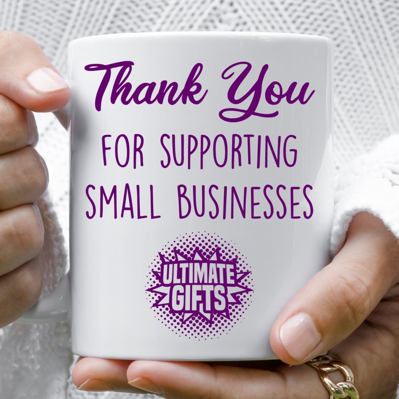 May include: White ceramic mug with purple text that reads "Thank You for Supporting Small Businesses" and a purple starburst with the text "Ultimate Gifts".