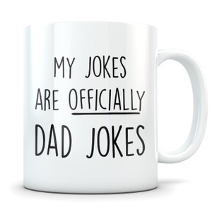 May include: White ceramic coffee mug with black text that reads "My jokes are officially dad jokes".