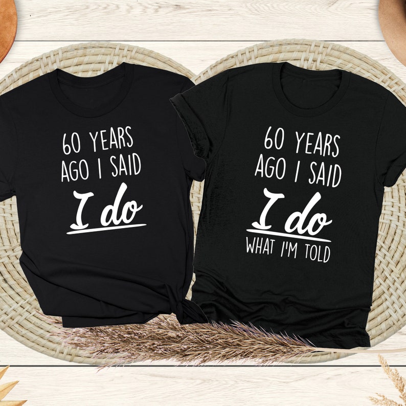 May include: Two black t-shirts with white text. The left shirt says "60 years ago I said I do". The right shirt says "60 years ago I said I do what I'm told".