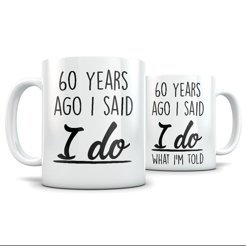 May include: White ceramic coffee mug with black text that reads "60 years ago I said I do" on one side and "60 years ago I said I do what I'm told" on the other side.