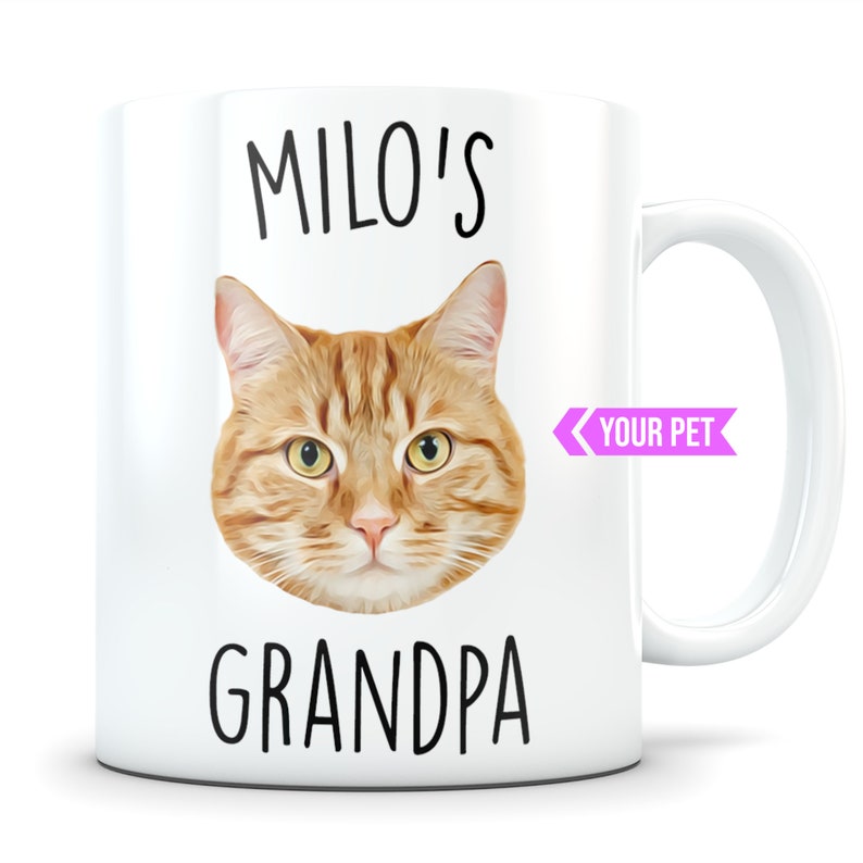 May include: White ceramic mug with a cartoon image of a ginger cat with the text "MILO'S GRANDPA" and a pink ribbon with the text "YOUR PET" on the side.
