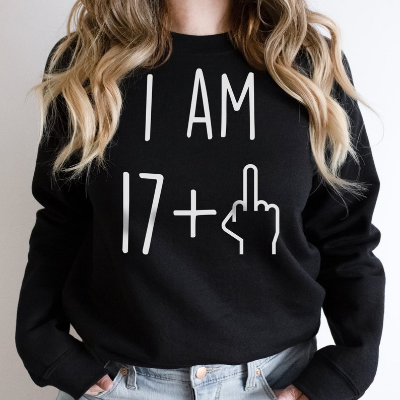 May include: Black sweatshirt with white text that reads "I AM 17+" with a middle finger emoji.