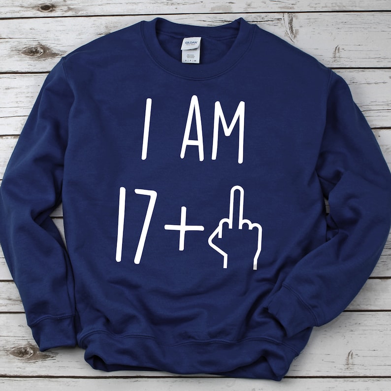 May include: A navy blue sweatshirt with the text "I AM 17+" and a middle finger emoji in white.
