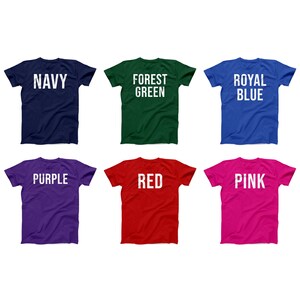 Pode incluir: Seis t-shirts de diferentes cores com texto na frente. As cores s&atilde;o azul marinho, verde floresta, azul royal, roxo, vermelho e rosa. O texto nas t-shirts diz "NAVY", "FOREST GREEN", "ROYAL BLUE", "PURPLE", "RED" e "PINK".