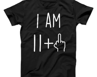 Puede incluir: Camiseta negra con texto blanco que dice "I AM 11 +" con un emoji de dedo medio.