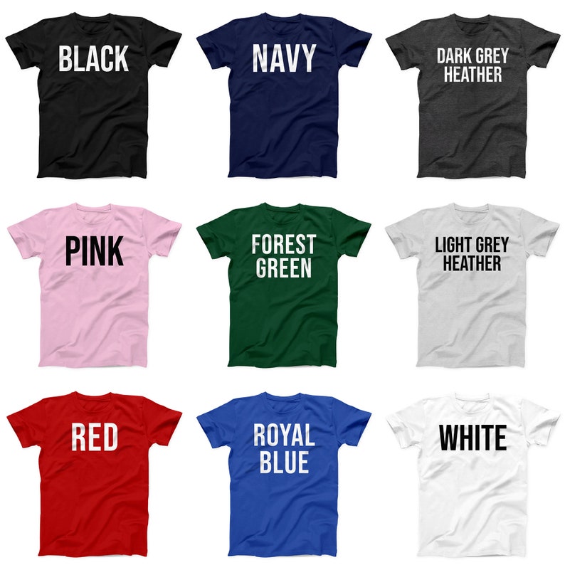 May include: Nine t-shirts in different colors with text on the front. The colors are black, navy, dark grey heather, pink, forest green, light grey heather, red, royal blue, and white. The text on the shirts includes "BLACK", "NAVY", "DARK GREY HEATHER", "PINK", "FOREST GREEN", "LIGHT GREY HEATHER", "RED", "ROYAL BLUE", and "WHITE".