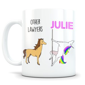 May include: White ceramic mug with a brown horse and a unicorn with a rainbow mane and tail. The text "OTHER LAWYERS" is above the horse and the text "JULIE" is above the unicorn.
