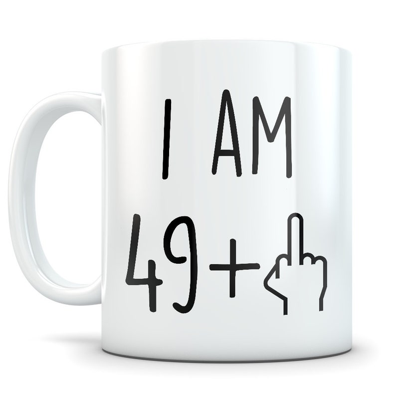 May include: White ceramic coffee mug with black text that reads "I AM 49+  " with a middle finger emoji.