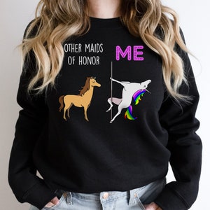 May include: Black sweatshirt with a graphic of a unicorn doing a pole dance and a horse standing next to it. The text "Other maids of honour" is above the horse and "ME" is above the unicorn.