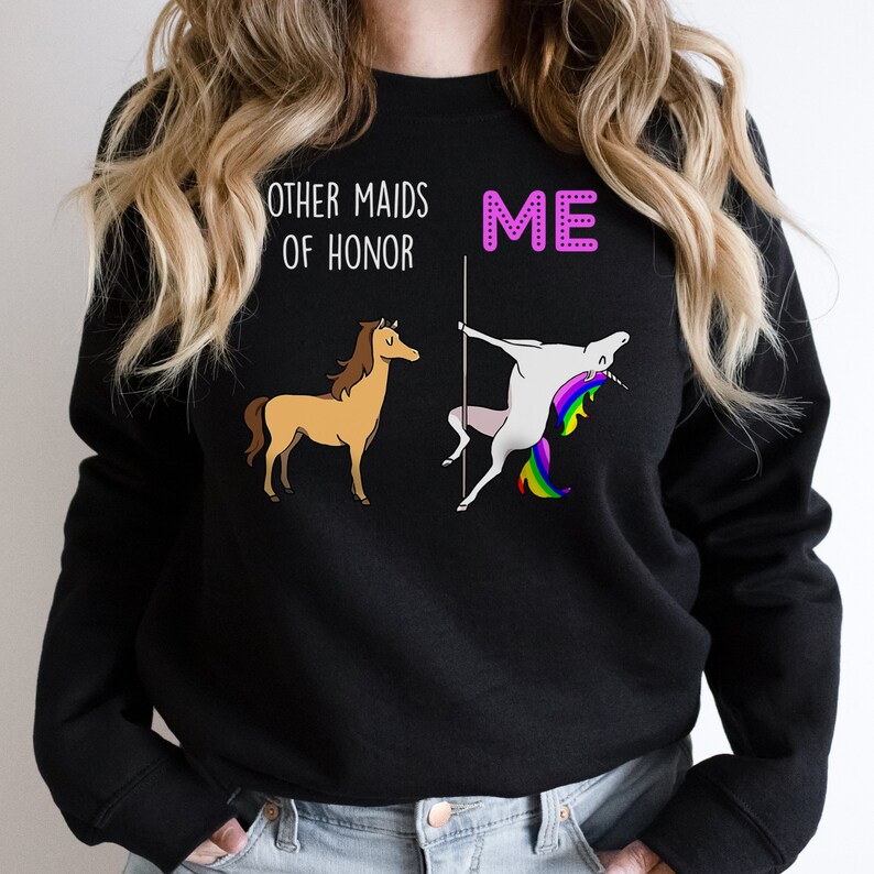 May include: Black sweatshirt with a graphic of a unicorn doing a pole dance and a horse standing next to it. The text "Other maids of honour" is above the horse and "ME" is above the unicorn.