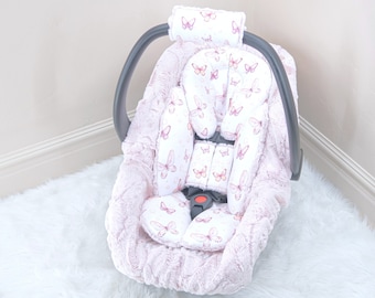 Può includere: Una copertura per seggiolino auto rosa per neonati con stampa a farfalla. La copertura è realizzata in tessuto morbido e peluche e include un poggiatesta e un inserto per il corpo.