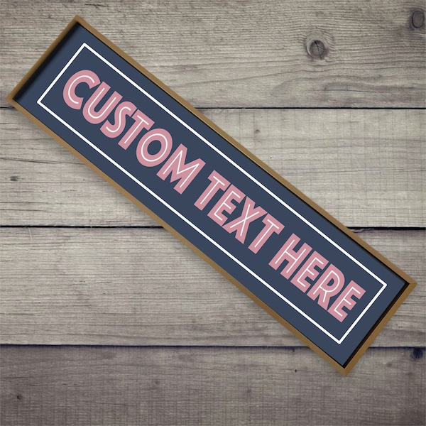 May include: A wooden sign with a gold frame and a navy blue background. The sign has white lettering that says "CUSTOM TEXT HERE" in a pink font.