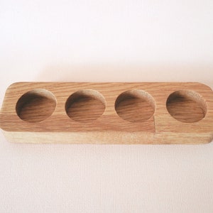 May include: A wooden tray with four circular indentations, perfect for holding small items like essential oils or jewelry.