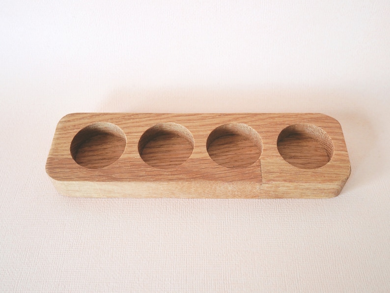 May include: A wooden tray with four circular indentations, perfect for holding small items like essential oils or jewelry.