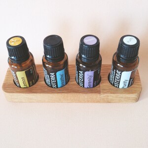 May include: Wooden essential oil holder with four amber glass bottles labeled "Lemon", "Breathe", "Serenity", and "Purity".