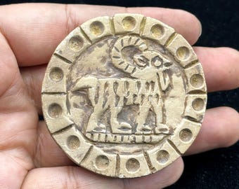 Azulejo antiguo de piedra caliza del Cercano Oriente con representación de un carnero.