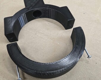 May include: Two black plastic pieces that can be joined together to form a ring. The pieces have a textured surface and are held together by screws.
