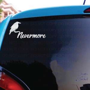 May include: A white vinyl decal applied to a car window featuring a silhouette of a raven perched on the word Nevermore written in a cursive script font. The design is positioned on the upper left side of the dark tinted rear vehicle glass.